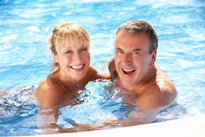 Senior Couple Having Fun In Swimming Pool